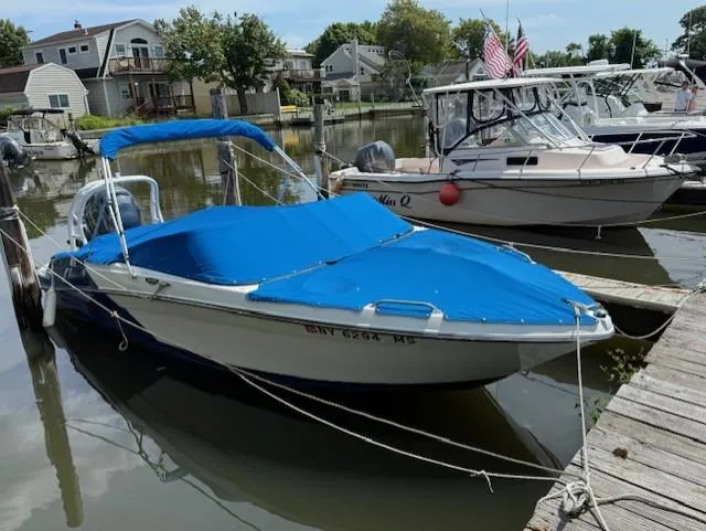 The Image of 2021 Glastron GX 210 Sport boat docked with blue cover and canopy. - 0