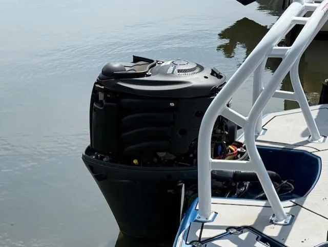 Slide: The Image of Outboard motor on a 2021 Glastron GX 210 Sport boat docked by water. - 19