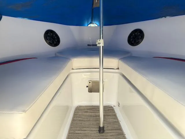 Slide: The Image of 2021 Glastron GX 210 Sport boat interior with cushioned seating and speakers. - 20