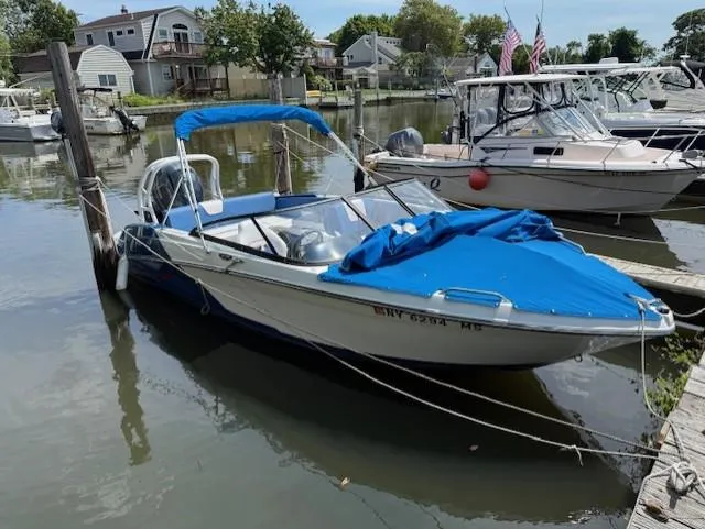 Slide: The Image of 2021 Glastron GX 210 Sport boat docked in a marina with blue cover. - 4