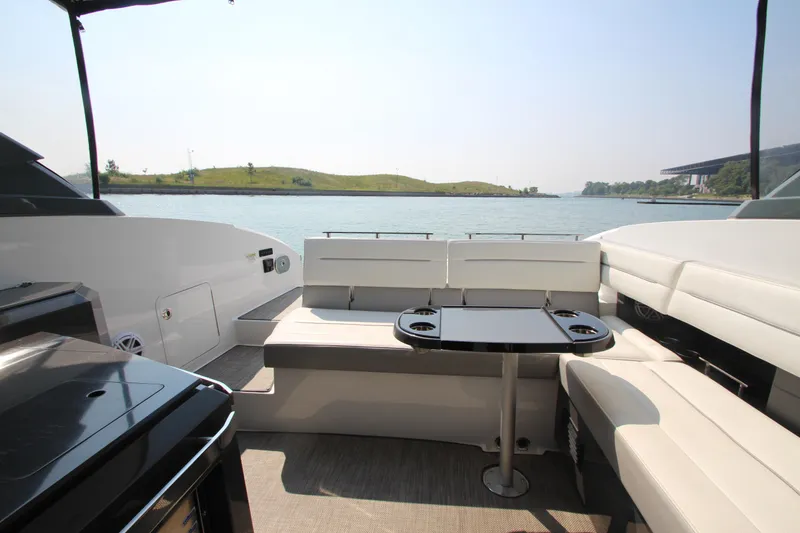 Slide: The Image of 2018 Cobalt A36 boat interior with seating and table, overlooking serene water view. - 22