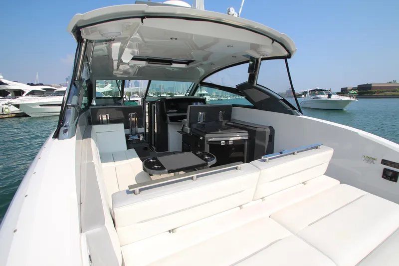 Slide: The Image of 2018 Cobalt A36 luxury boat interior with white seating, docked in a marina. - 32