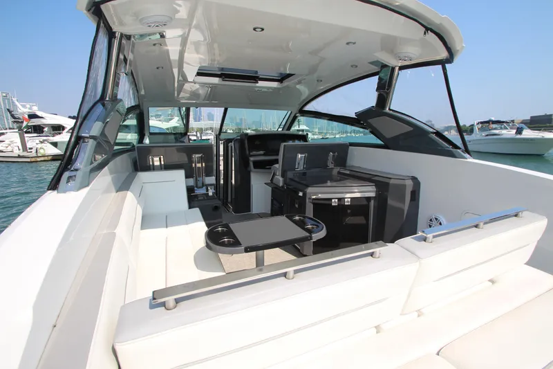 Slide: The Image of 2018 Cobalt A36 boat interior with seating and kitchenette, docked in a marina. - 33