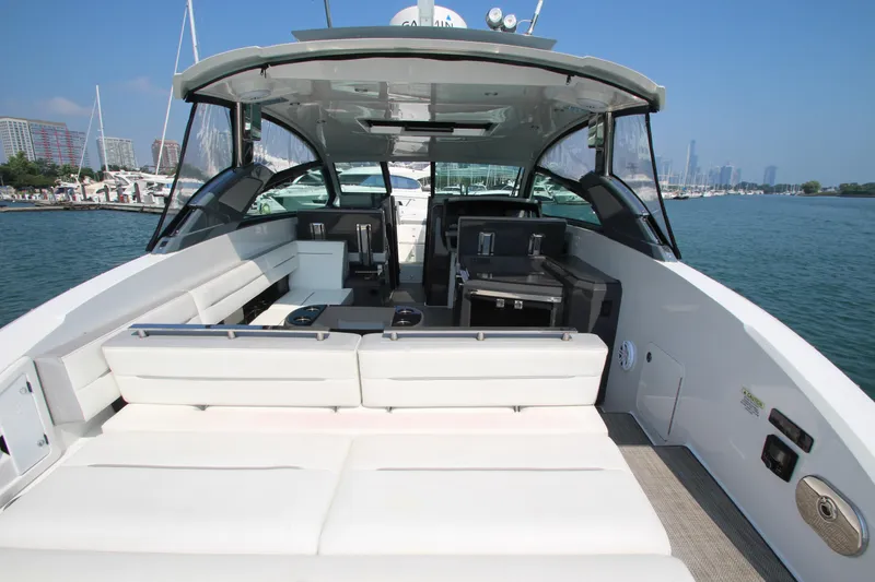 Slide: The Image of 2018 Cobalt A36 boat interior with spacious seating, docked in a marina under clear blue skies. - 34