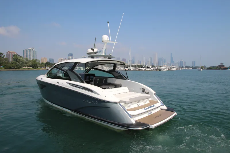 Slide: The Image of 2018 Cobalt A36 boat cruising on a scenic waterfront with city skyline. - 4