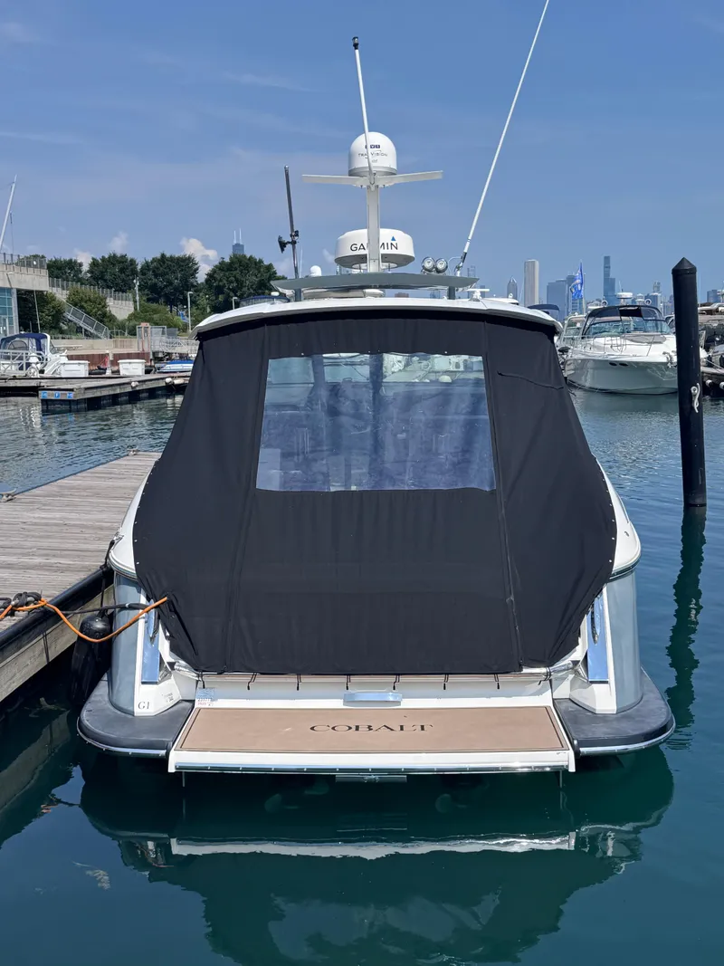 Slide: The Image of 2018 Cobalt A36 boat docked at marina with black cover. - 63