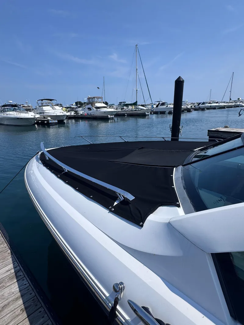 Slide: The Image of 2018 Cobalt A36 boat docked at marina with other vessels in background. - 64