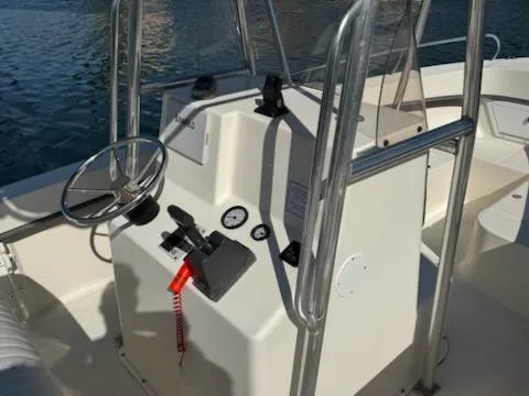 Slide: The Image of 2007 May-Craft 2000 boat console with steering wheel and controls, docked on water. - 7