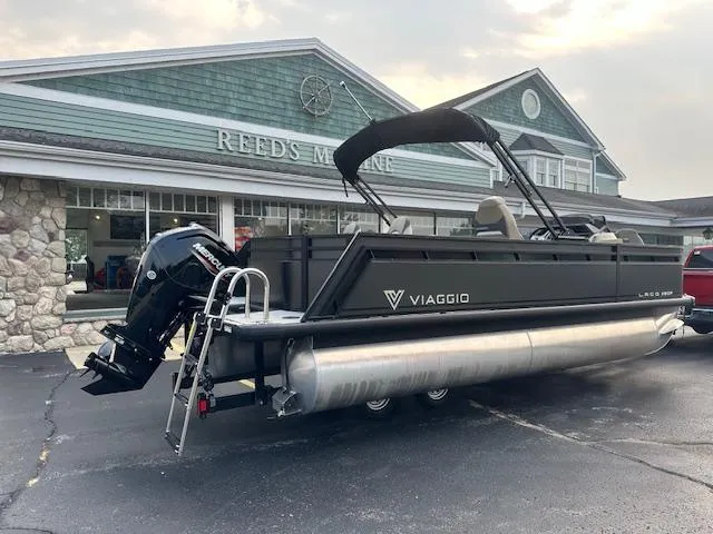 Slide: The Image of 2025 Viaggio Lago X-F pontoon boat parked at Reed's Marine dealership. - 1