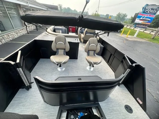 Slide: The Image of 2025 Viaggio Lago X-F boat interior with seating and canopy, parked outdoors. - 6