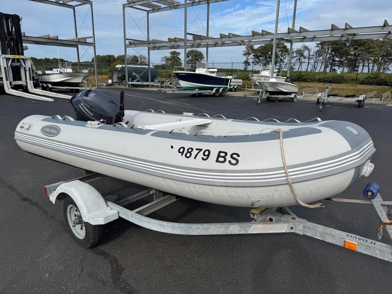 Slide: The Image of 2022 West Marine RIB-350 inflatable boat on trailer, parked in marina lot. - 3