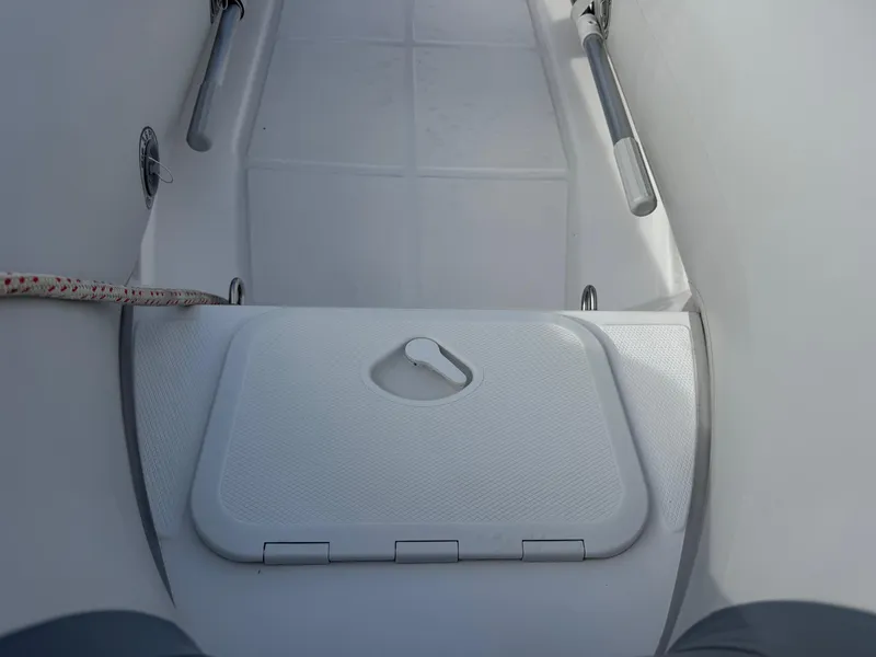 Slide: The Image of 2022 West Marine RIB-350 boat interior with storage compartment and oar holders. - 5