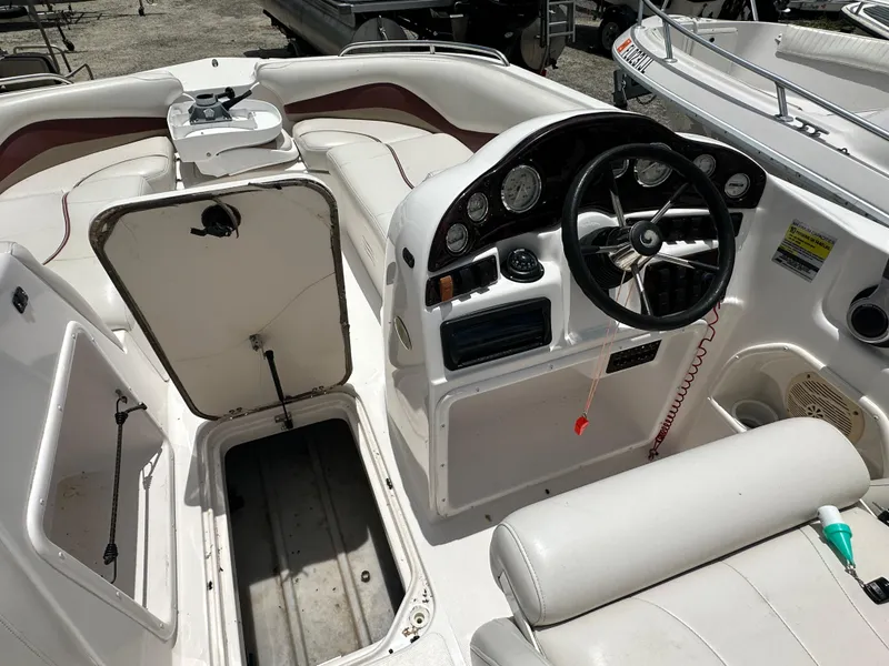 Slide: The Image of 2004 Hurricane FunDeck GS 202 OB boat interior with open storage compartments and steering console. - 9