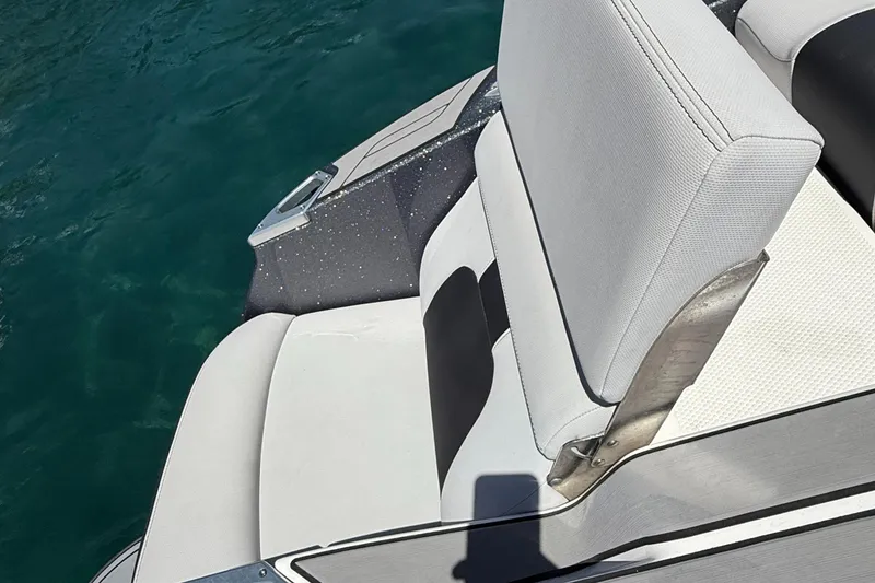 Slide: The Image of 2021 MasterCraft X24 boat interior with white seating and blue water background. - 12