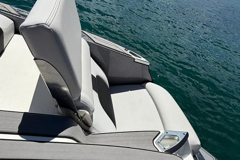 Slide: The Image of 2021 MasterCraft X24 boat interior with gray seating, near water. - 13