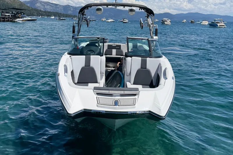 Slide: The Image of 2021 MasterCraft X24 boat on clear blue water with scenic mountain backdrop. - 5