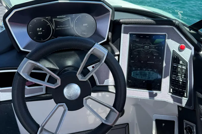 Slide: The Image of 2021 MasterCraft X24 dashboard with steering wheel and digital display on a sunny day. - 6