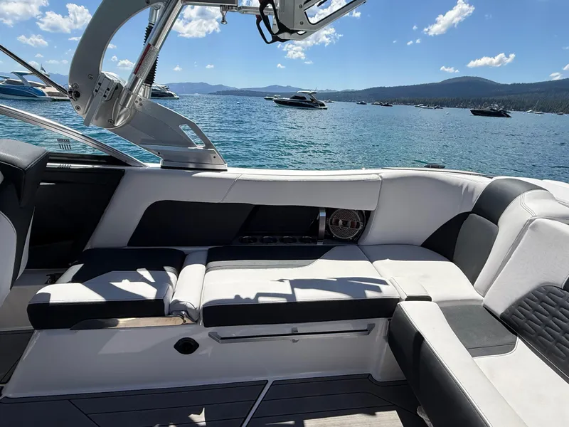 Slide: The Image of 2021 MasterCraft X24 boat interior with luxurious seating on a sunny lake. - 9