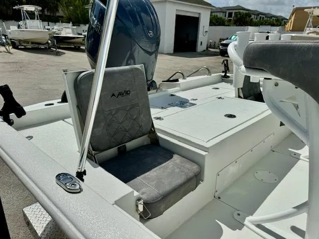 Slide: The Image of Avid 21 Mag 2025 boat interior with seating and motor in a marina setting. - 12