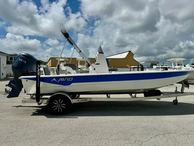Slide: The Image of Avid 21 Mag 2025 boat on trailer, parked outdoors under cloudy sky. - 6