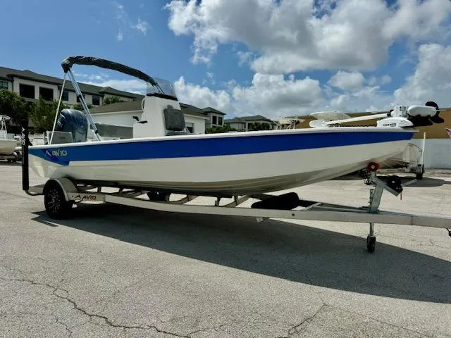 Slide: The Image of 2025 Avid 21 Mag boat on trailer under a partly cloudy sky. - 7