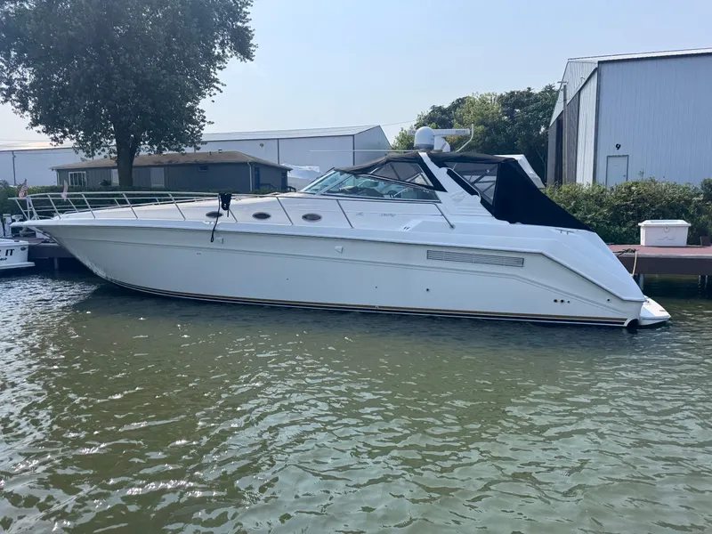 The Image of 1994 Sea Ray 500 Sundancer yacht docked by a marina, side view. - 0