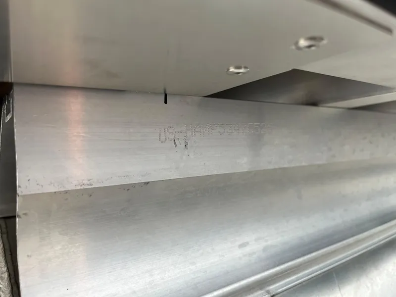 Slide: The Image of Close-up of a 2026 Harris Cruiser 230 metal component with engraved serial number. - 23