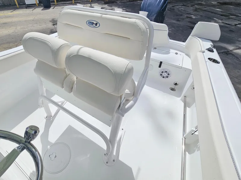 Slide: The Image of 2025 Sea Hunt Ultra 235 SE boat interior with white seating and steering wheel. - 12