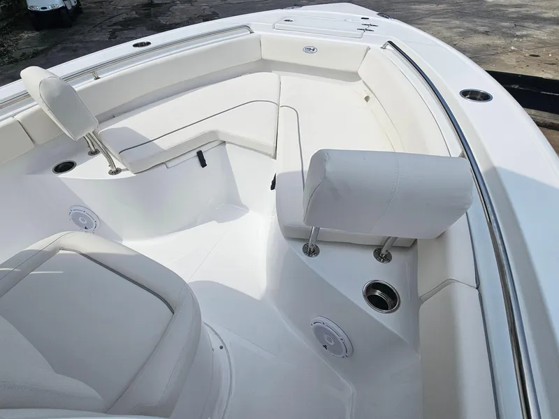 Slide: The Image of 2025 Sea Hunt Ultra 235 SE boat interior with white seating and stainless steel fixtures. - 16