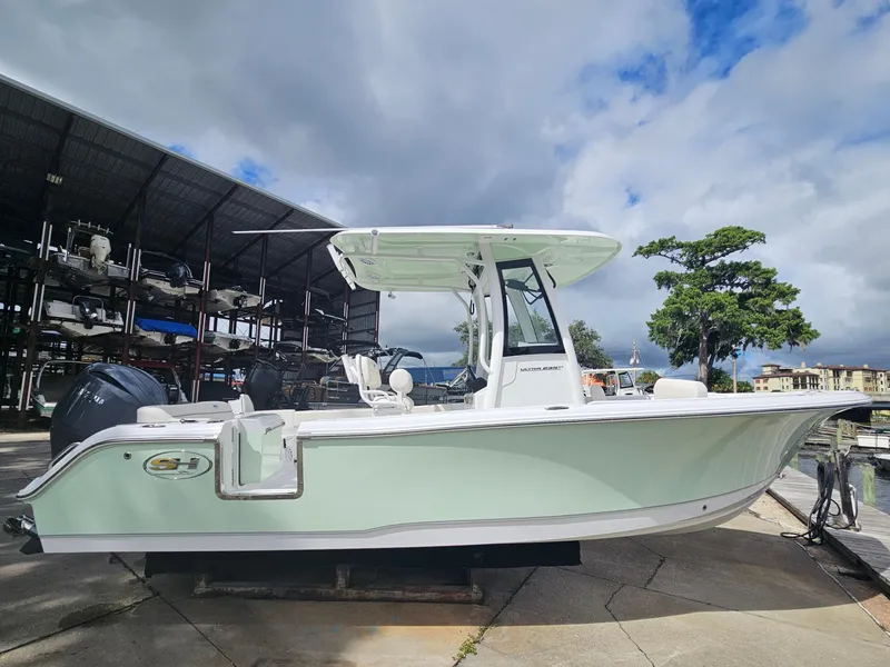 Slide: The Image of 2025 Sea Hunt Ultra 235 SE boat docked under cloudy sky. - 4