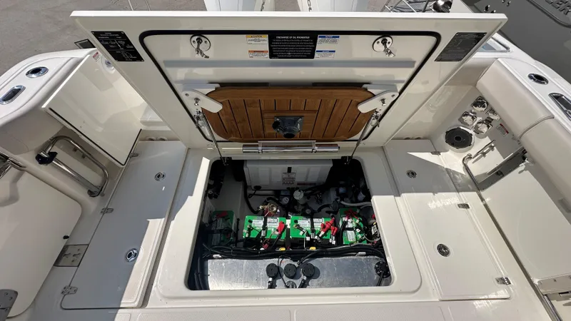 Slide: The Image of Open engine compartment of 2026 Boston Whaler 325 Conquest boat, showcasing battery setup. - 13