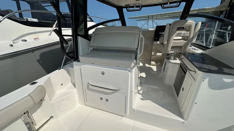 Slide: The Image of 2026 Boston Whaler 325 Conquest interior with seating and control panel. - 19