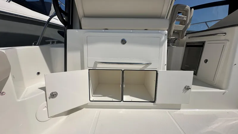 Slide: The Image of 2026 Boston Whaler 325 Conquest interior storage compartments open, showcasing sleek design. - 23