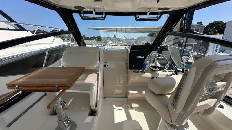 Slide: The Image of Interior of 2026 Boston Whaler 325 Conquest boat with seating and navigation equipment. - 28