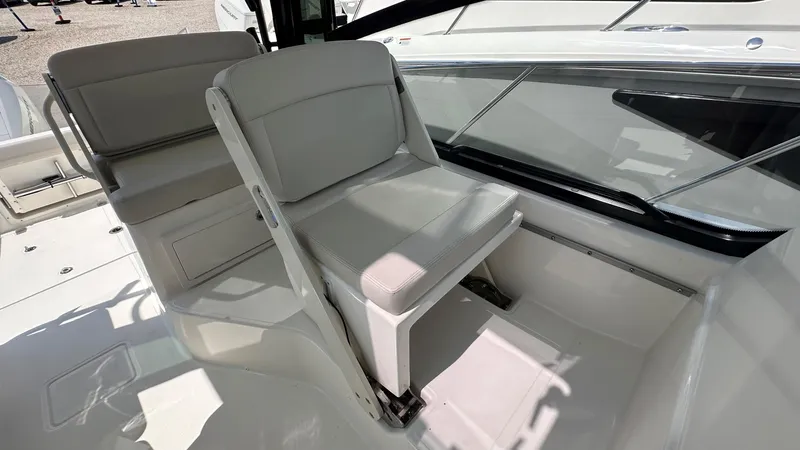 Slide: The Image of 2026 Boston Whaler 325 Conquest interior seating area with white upholstery and sleek design. - 30