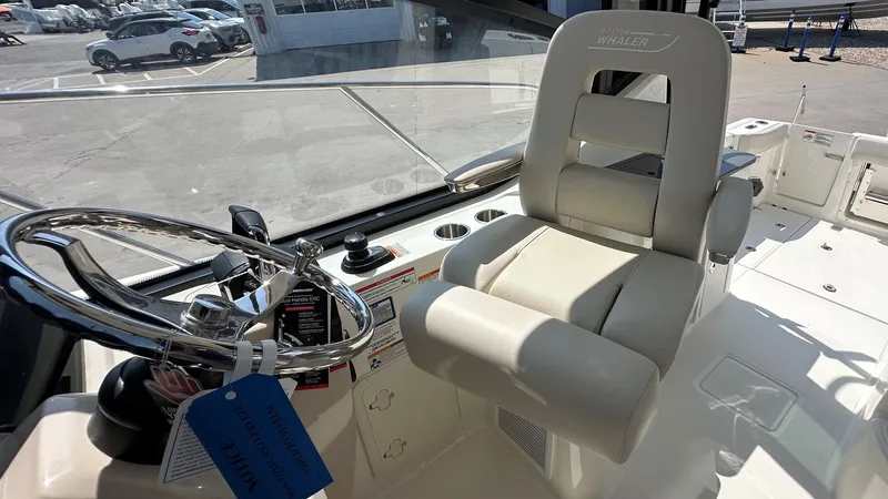 Slide: The Image of 2026 Boston Whaler 325 Conquest helm with steering wheel and captain's chair. - 35