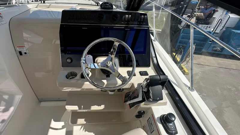 Slide: The Image of 2026 Boston Whaler 325 Conquest helm with steering wheel and navigation controls. - 36