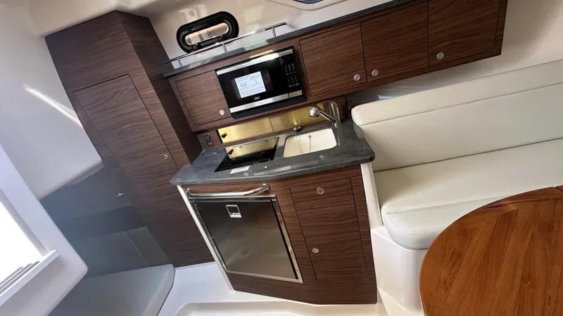 Slide: The Image of Interior of 2026 Boston Whaler 325 Conquest, featuring a modern kitchenette and seating area. - 44