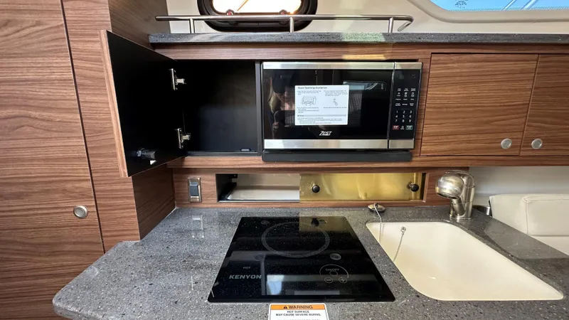 Slide: The Image of Modern kitchen area in 2026 Boston Whaler 325 Conquest boat with microwave and stove. - 46