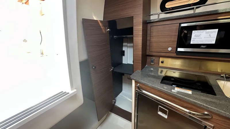Slide: The Image of Interior of 2026 Boston Whaler 325 Conquest, featuring modern kitchen amenities and storage. - 48