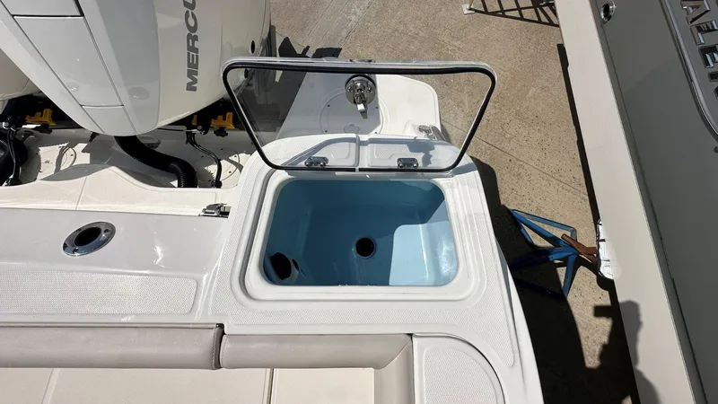 Slide: The Image of 2026 Boston Whaler 325 Conquest boat with open storage compartment and visible Mercury engine. - 5
