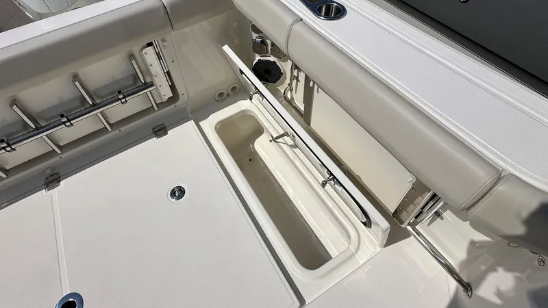 Slide: The Image of 2026 Boston Whaler 325 Conquest deck with storage compartment and rod holders. - 9