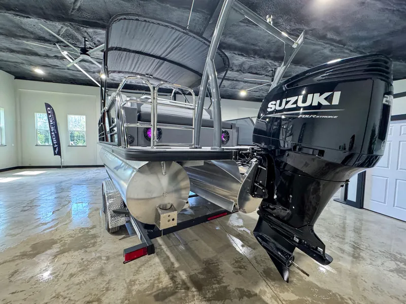 Slide: The Image of 2025 Berkshire 23SBE STS pontoon boat with Suzuki outboard motor in a showroom. - 15