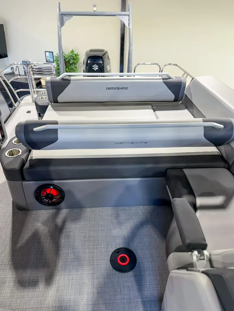 Slide: The Image of 2025 Berkshire 23SBE STS boat interior with seating, cup holders, and speaker. - 22