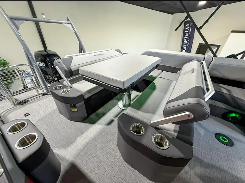 Slide: The Image of 2025 Berkshire 23SBE STS boat interior with seating, table, and cup holders. - 27