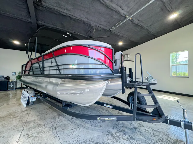 Slide: The Image of 2025 Berkshire 23SBE STS pontoon boat in showroom, featuring sleek design and vibrant red accents. - 7