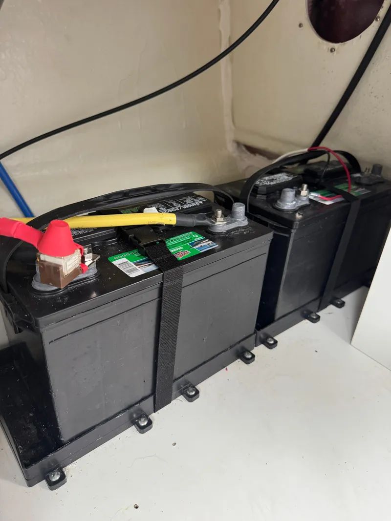 Slide: The Image of Batteries installed in a 2020 Jeanneau NC 795 boat, secured with straps. - 24