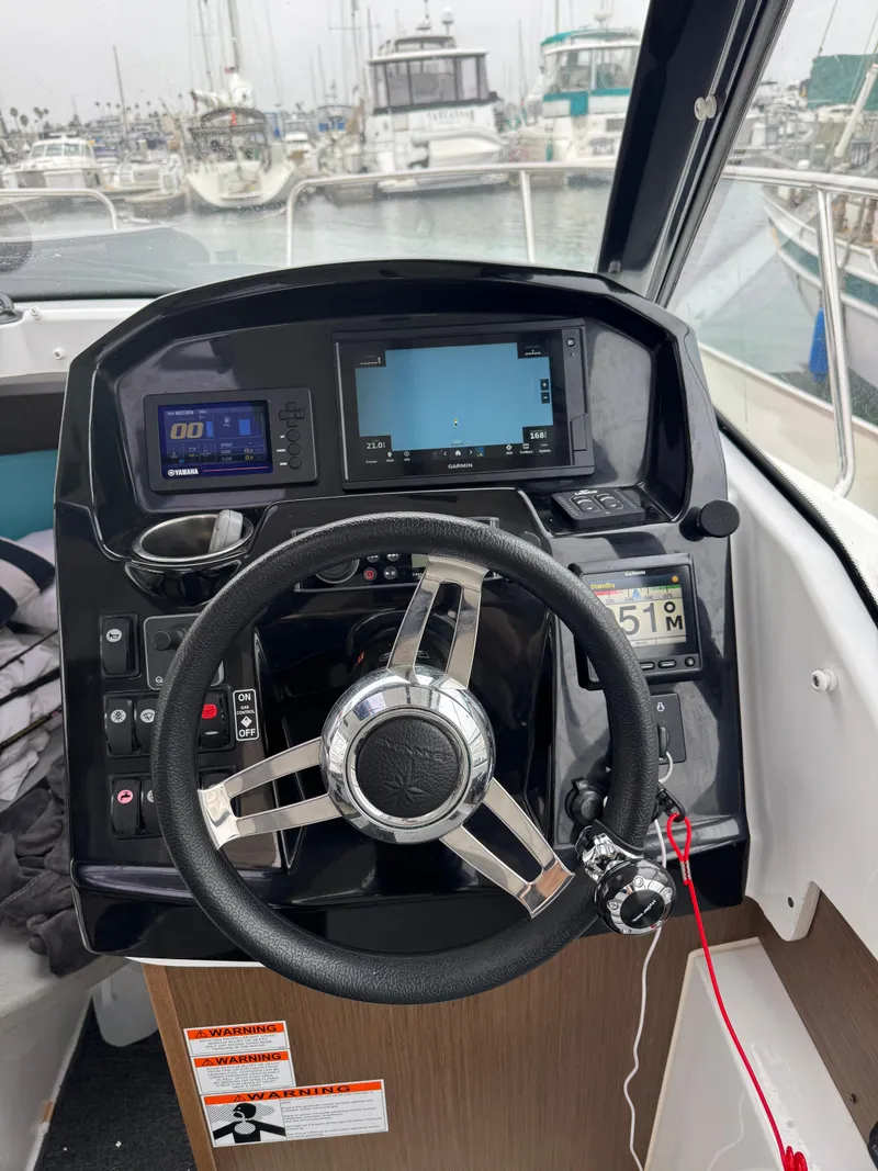 Slide: The Image of Steering console of a 2020 Jeanneau NC 795 boat with navigation displays. - 42