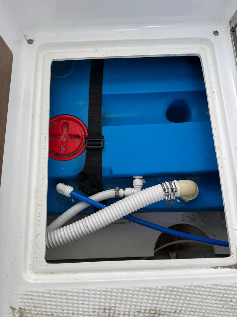 Slide: The Image of Jeanneau NC 795 2020 boat compartment with blue tank and hoses. - 49