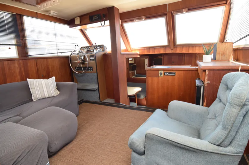 Slide: The Image of 1977 Uniflite 42 Double Cabin interior with cozy seating and wooden helm station. - 10